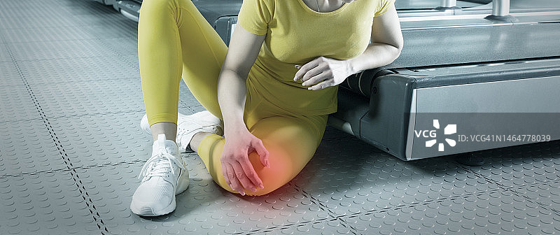 穿着运动服的年轻女人在训练中膝盖疼痛图片素材