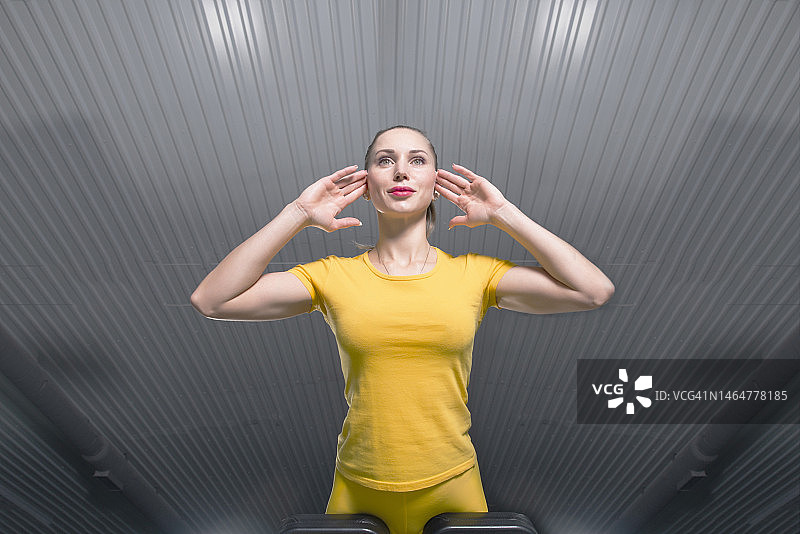 年轻运动型女人在健身房使用腹肌训练器（由下往上视角）图片素材