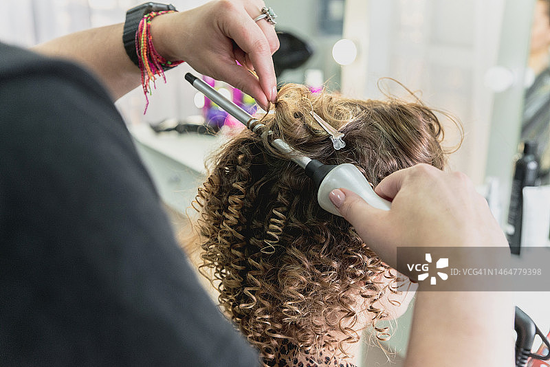 发型师在美发沙龙为女士做造型特写图片素材