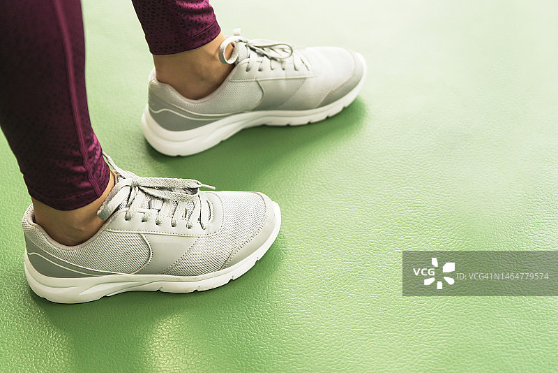 健身房里穿运动鞋的女人的腿部特写，带文案空间图片素材