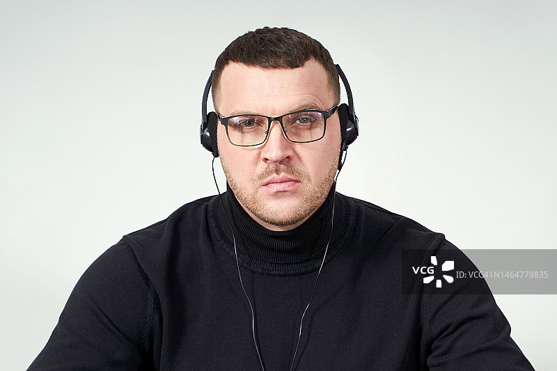 戴着耳机专心使用笔记本电脑的男人图片素材