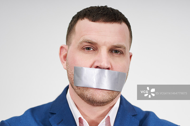 男人的嘴巴被一大块黑色工业胶带封住图片素材