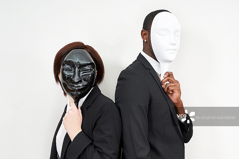 身穿黑色西装遮住脸的非洲男子和白人女子图片素材