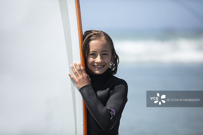 年轻女孩穿潜水服上冲浪课图片素材