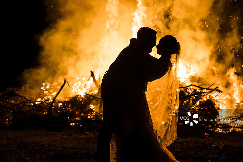 新娘和新郎的剪影，背景是火焰图片素材
