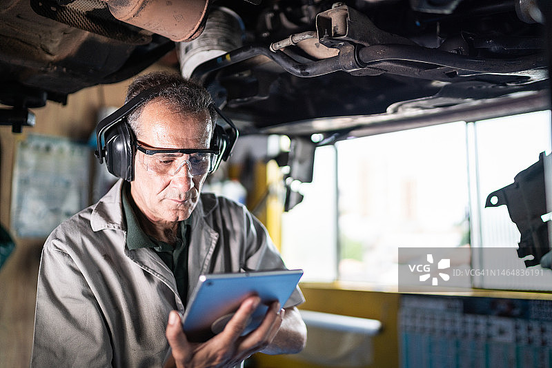 汽车修理工在修理店使用数位平板电脑图片素材