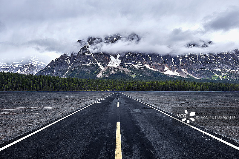 雪山背景下的笔直高速公路图片素材