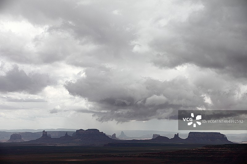 纪念碑谷多云天空下的孤山岩层剪影图片素材