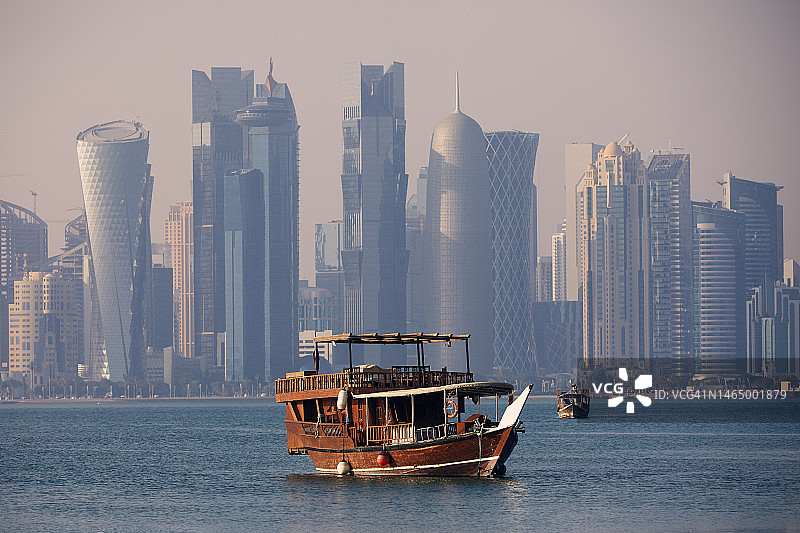 城市天际线背景下的传统木船图片素材