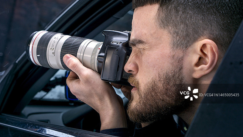 年轻摄影师在车窗旁特写拍摄，一位联邦调查局特工进行监视和拍照图片素材