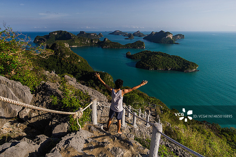 男子站在梯子上，眺望安通群岛、苏梅岛的碧绿海景，泰国素叻他尼省图片素材