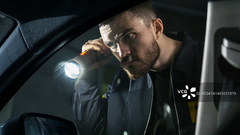 帅气FBI探员手电筒检查汽车图片素材