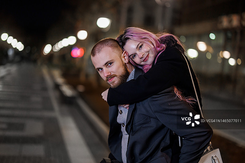 年轻男子在城市漫步中与女友共度美好夜晚图片素材
