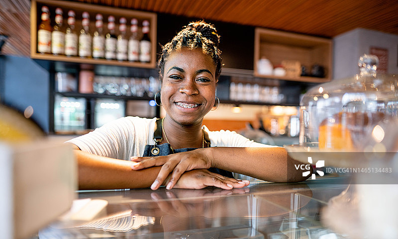 咖啡师在咖啡馆柜台后微笑图片素材