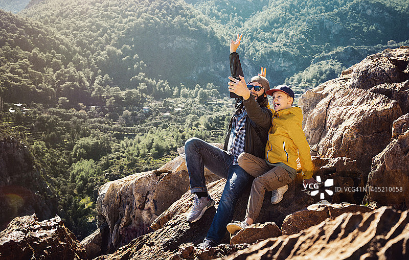 父子在山中旅行，用智能手机自拍图片素材