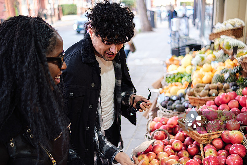 年轻夫妇在市场上挑选农产品图片素材