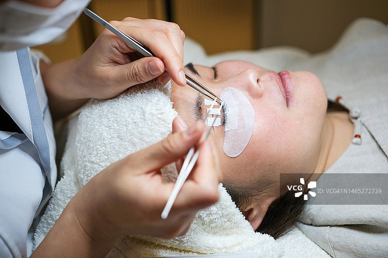 美容师为顾客嫁接假睫毛图片素材