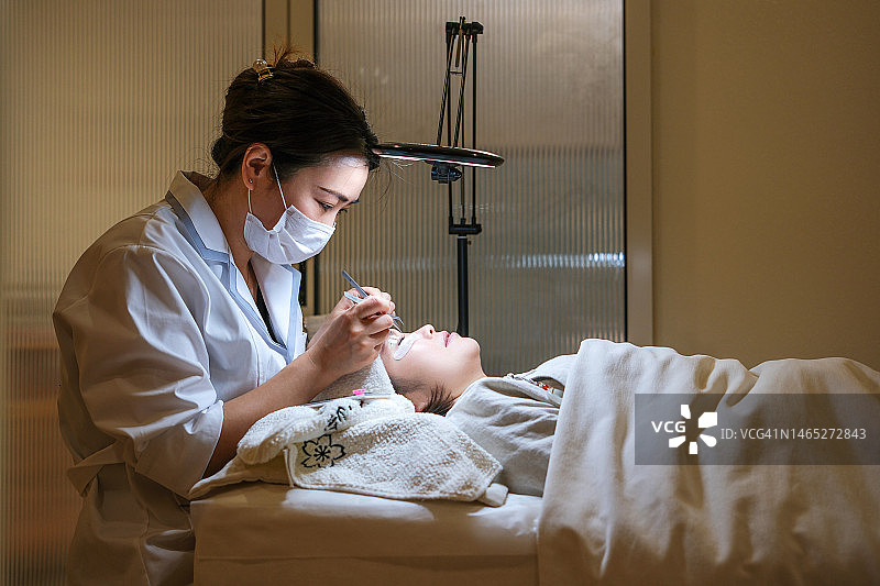 美容师为顾客嫁接假睫毛图片素材