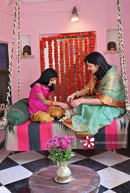 印度母女秋千上制作花串图片素材