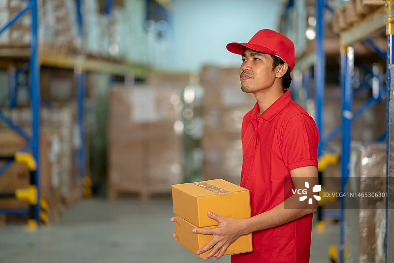 在仓库工作的亚洲送货员图片素材