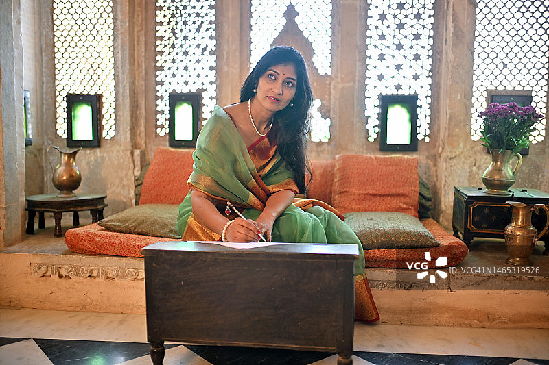 印度女人用老式墨水笔写作的复古场景图片素材