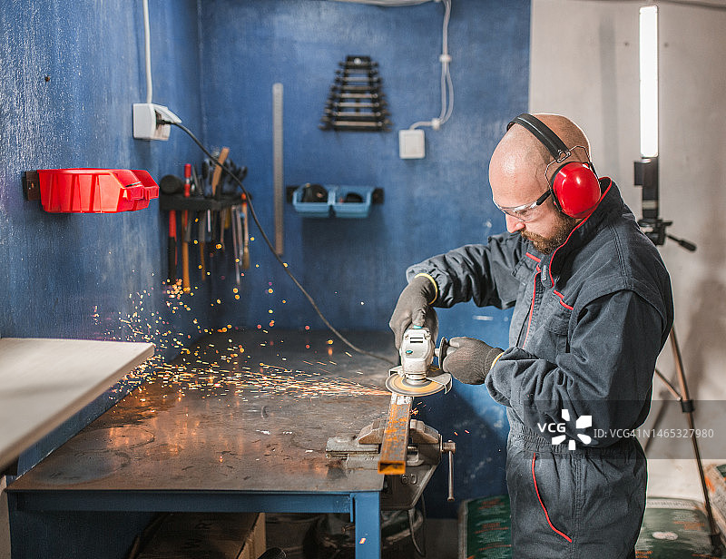 金属工人在金属车间使用砂轮机图片素材