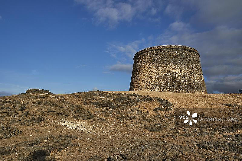 托斯顿城堡,圆形堡垒塔楼,贫瘠的山丘,蓝天与灰白色的云彩,西海岸,富埃特文图拉岛,加那利群岛,西班牙图片素材