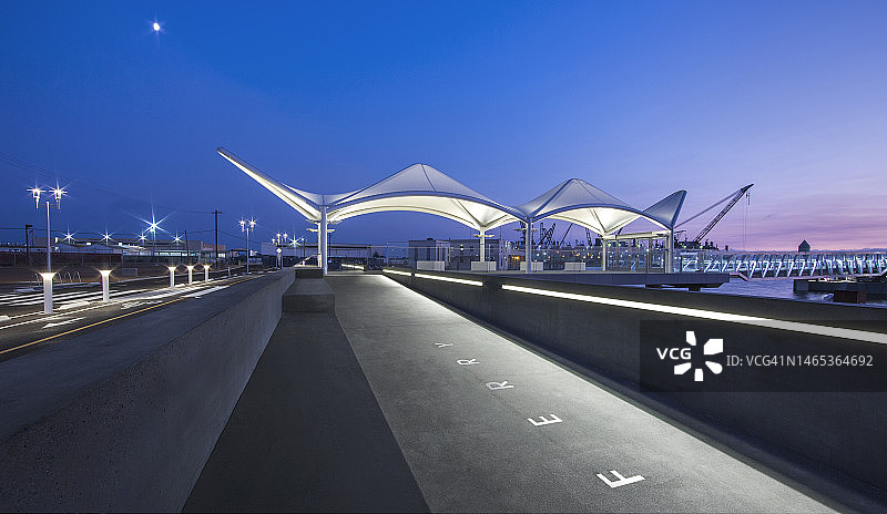 日落时分由节能LED灯照亮的公共客运渡轮码头图片素材