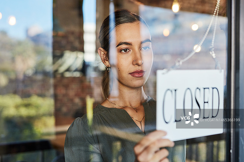 咖啡店主和店员因店铺倒闭而难过，在餐厅门前张贴暂停营业告示图片素材