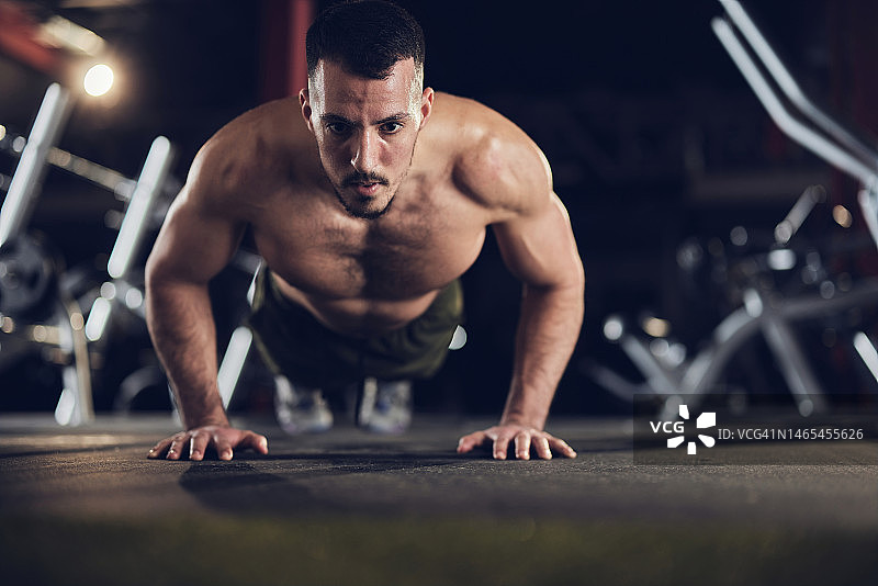 在健身房做俯卧撑的健壮男子图片素材