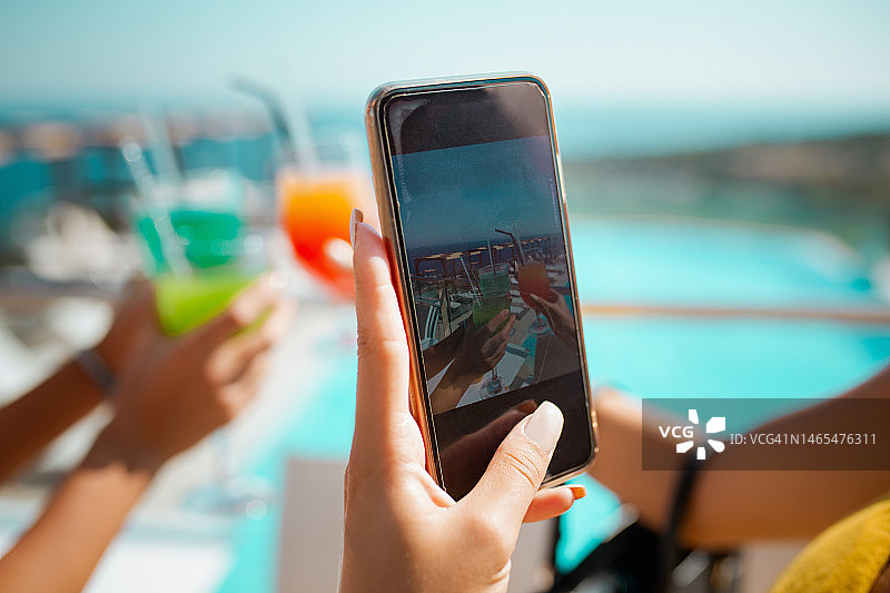 在夏季度假胜地的鸡尾酒会上用手机拍照图片素材