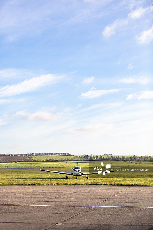 停放在草地机场的小型单引擎螺旋桨飞机图片素材
