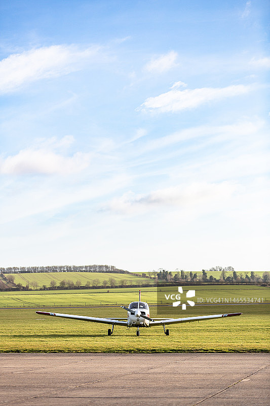 停放在草地机场的小型单引擎螺旋桨飞机图片素材