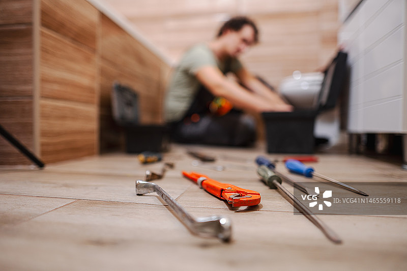 水管工修理厕所时浴室地板上的工具图片素材