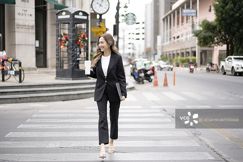 年轻女人在上班路上喝咖啡图片素材