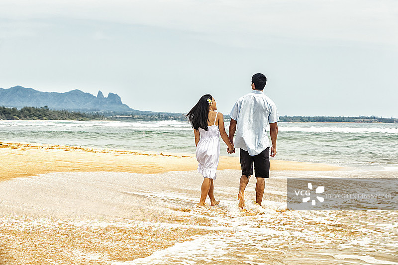 快乐情侣在夏威夷海滩漫步图片素材