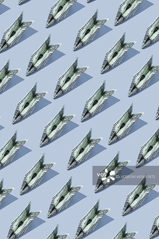 蓝色背景上的飞机造型美元纸币图片素材