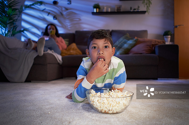 拉丁男孩在家里的客厅里看电影图片素材