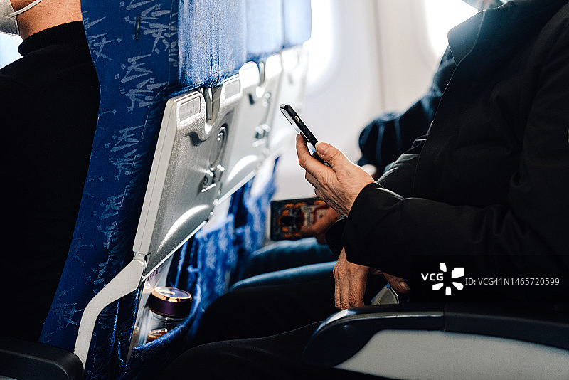 在飞机上看手机的乘客图片素材