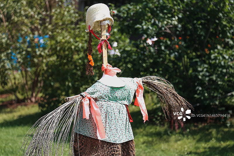 阳光明媚的夏日，稻草人守护着花园图片素材