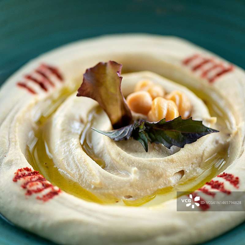 蓝色盘子配鹰嘴豆泥和皮塔饼。阿拉伯美食，犹太美食。鹰嘴豆菜肴。丰盛的小吃。素食。餐厅供应鹰嘴豆泥。虚焦。特写。顶视图图片素材