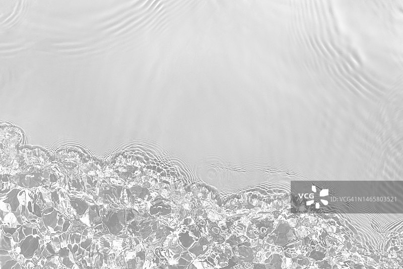 阳光下具有波纹、飞溅和波浪的低饱和度透明清水表面纹理图片素材