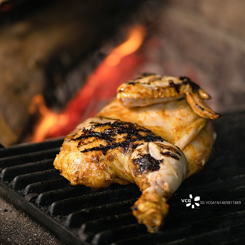烤架上烤的鸡骨架，背景是燃烧的煤炭图片素材