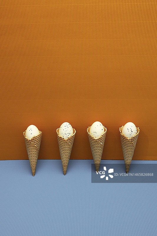 复活节彩蛋和黄蓝色背景上的冰淇淋华夫饼图片素材