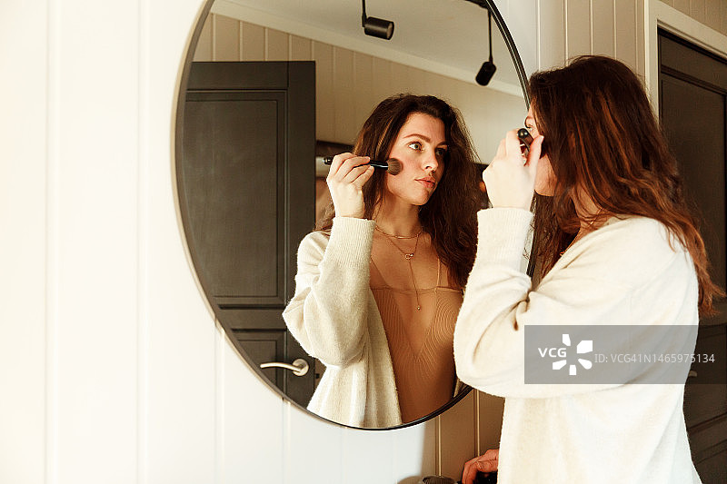 在镜子前化妆的女人图片素材