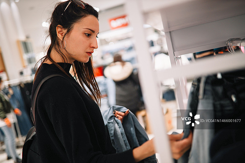 女人在服装店购买牛仔裤图片素材