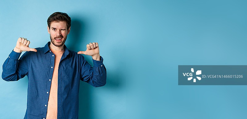 自信男人眨眼指向自己，自我推销图片素材