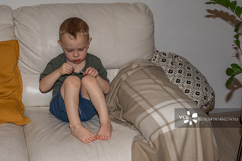 赤脚男孩坐在沙发上图片素材