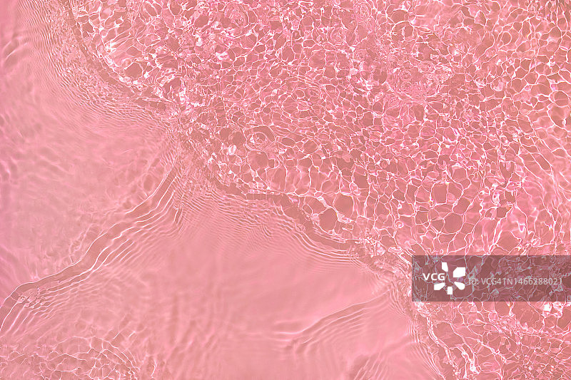 阳光下带有波纹的浅粉色透明水面纹理图片素材