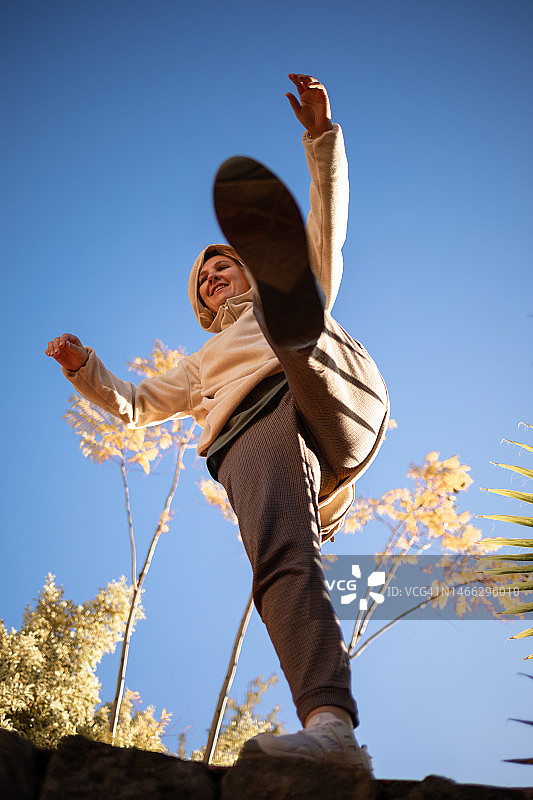 一个快乐的女孩跳起来同时展示她的腿图片素材